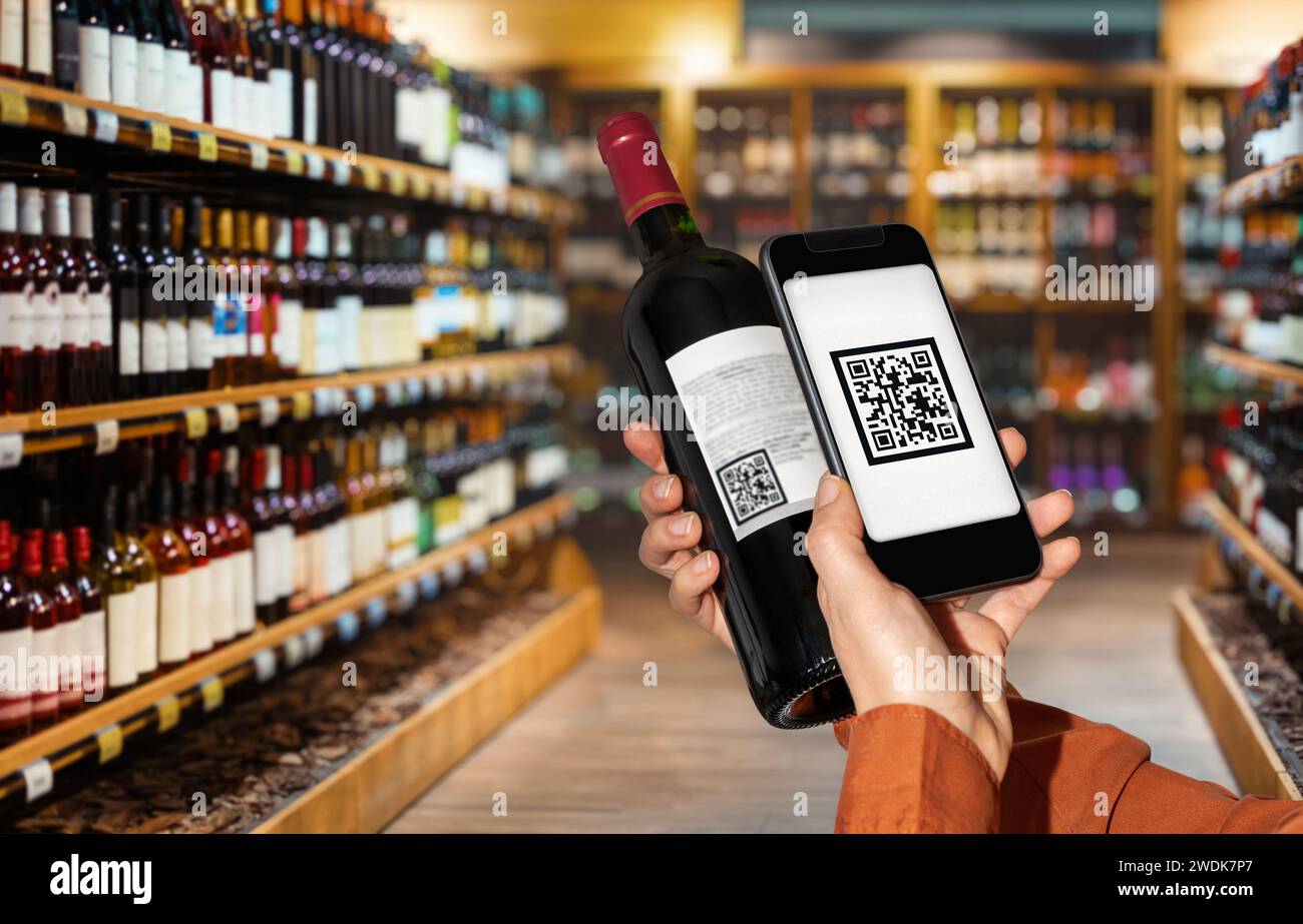 Customer scans qr code on wine bottle by smart phone in liquor store