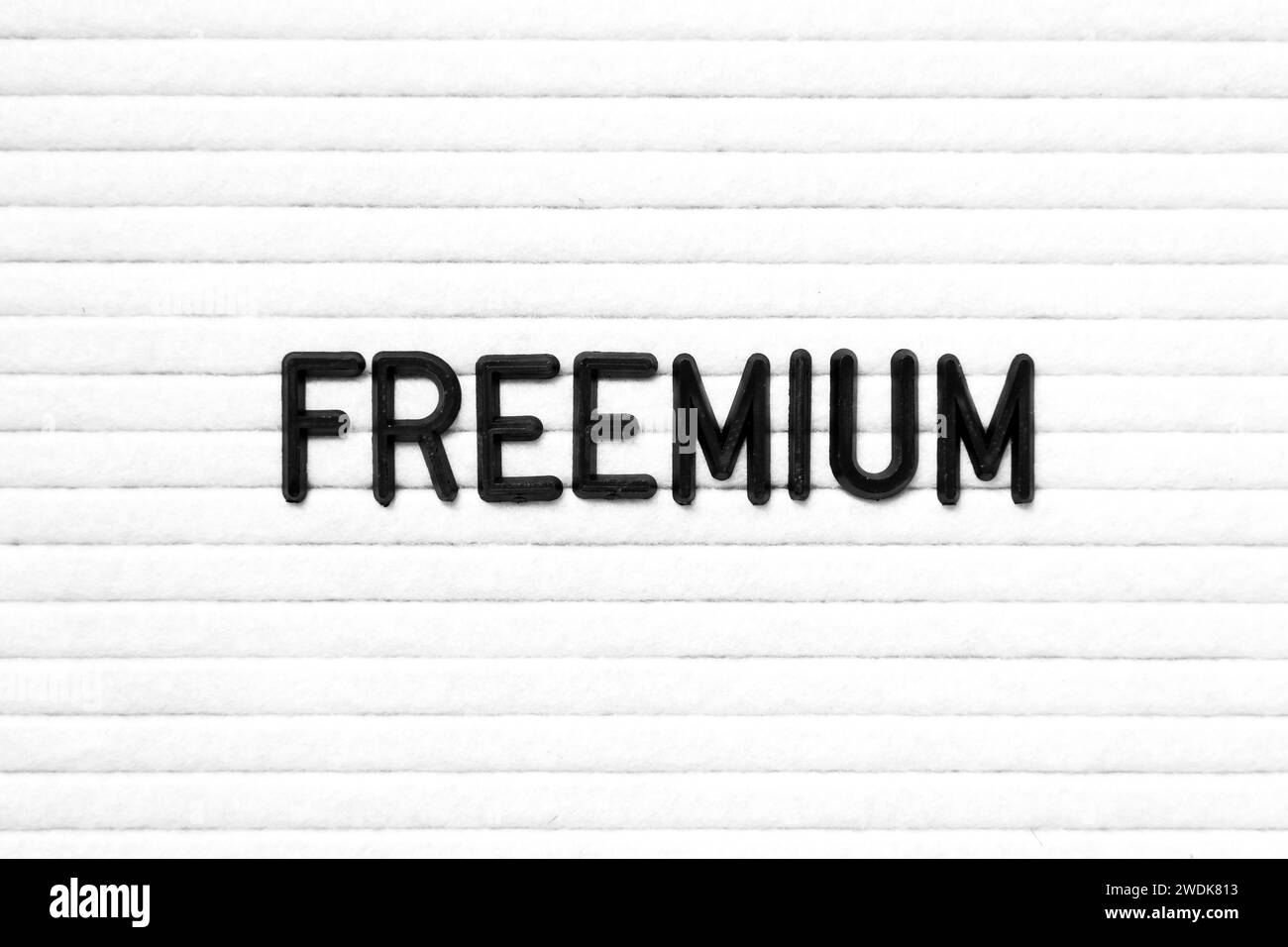 Black color letter in word freemium on white felt board background ...