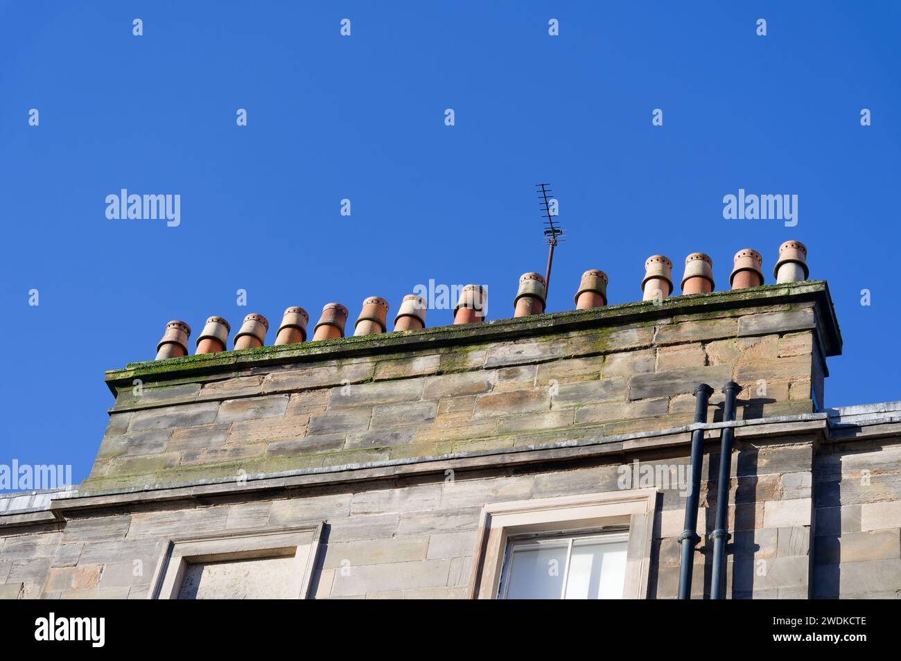 Chimney pots in a row on old victorian building roof Stock Photo