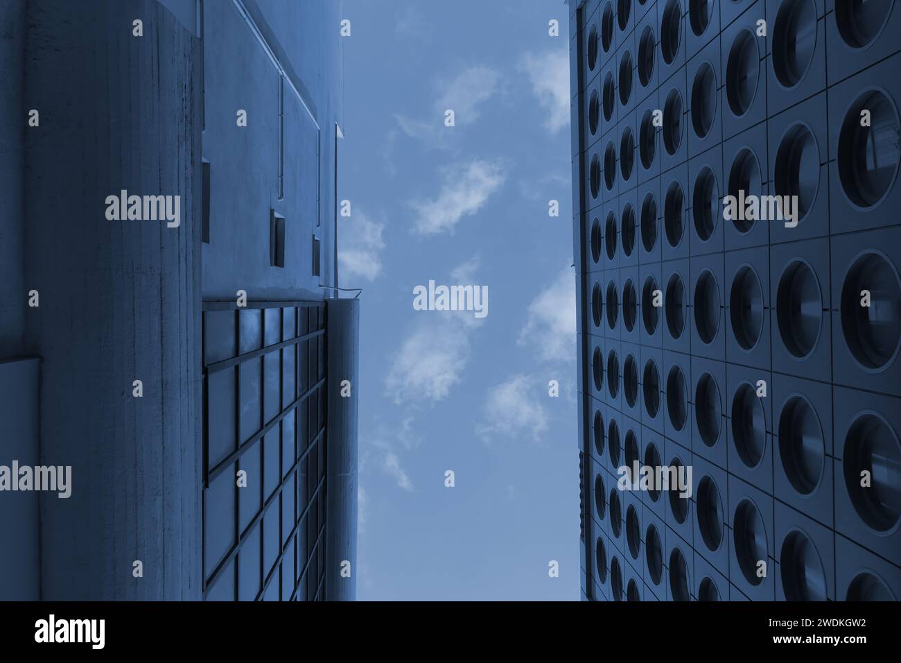 Patch of blue sky between two modern buildings. Abstract architectural detail tint. Stock Photo