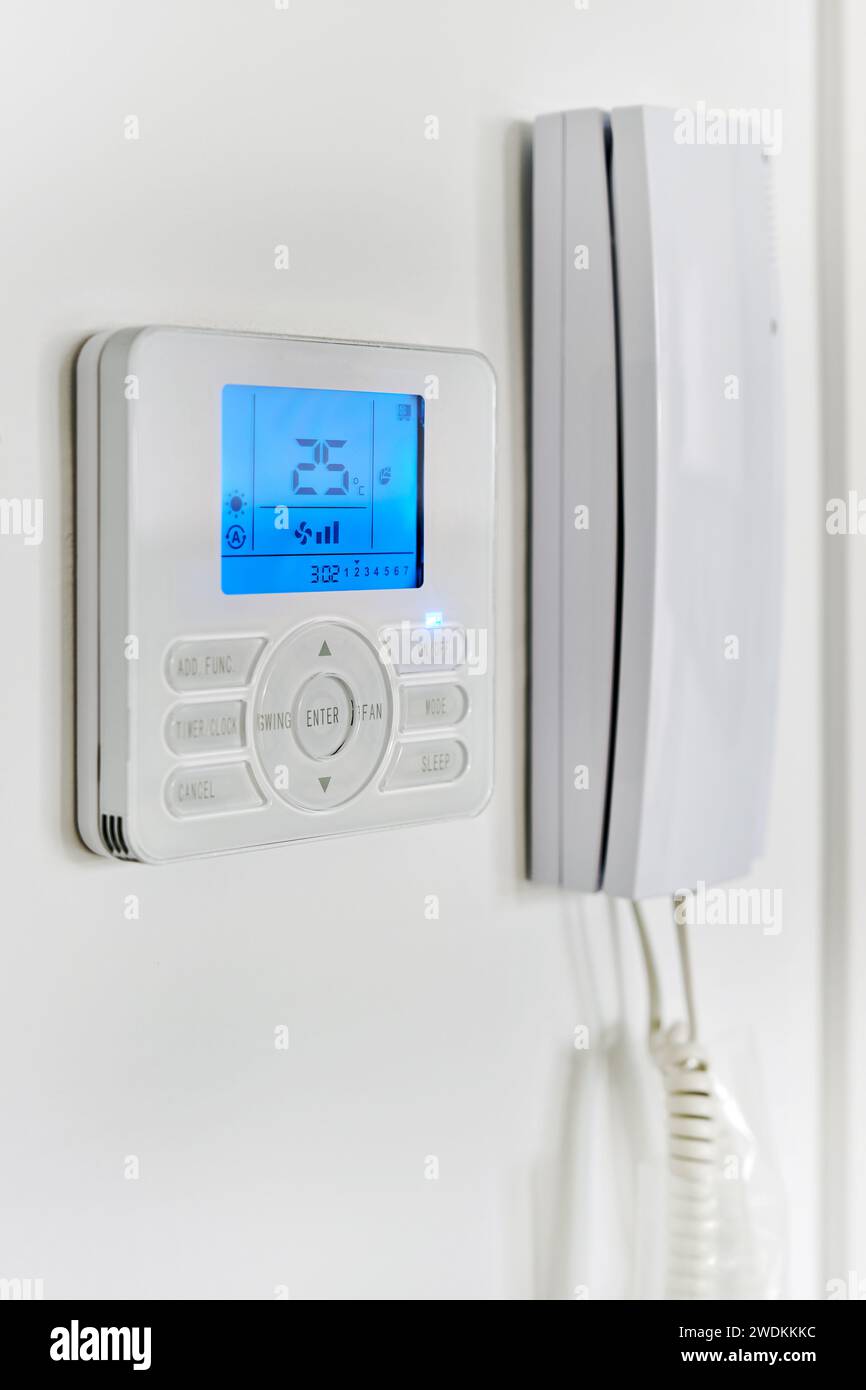 Video intercom with talkback or doorphone voice communications system mounted on wall, close up view. Climate control show 25 degrees indoor, remote a Stock Photo