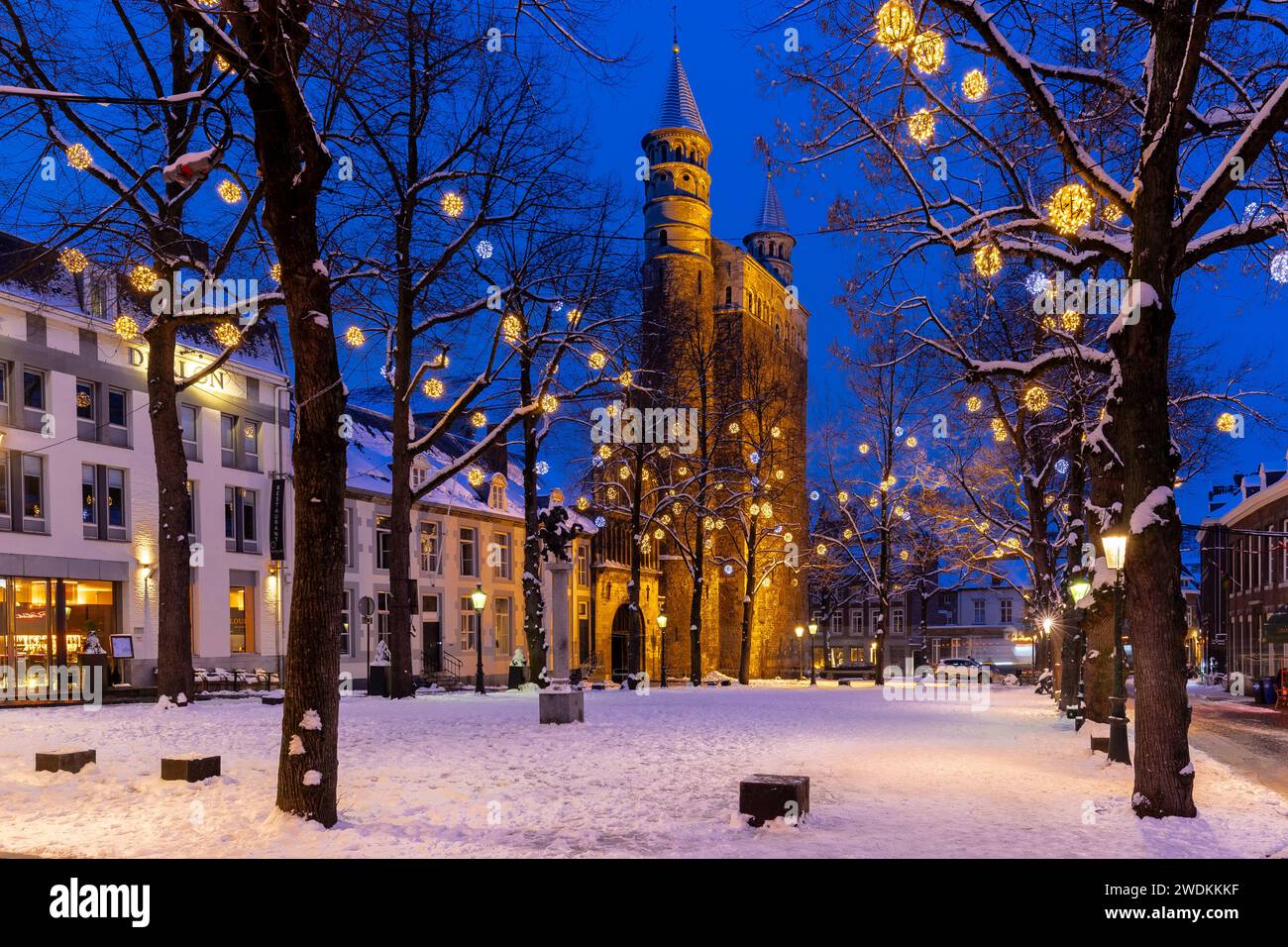 Basilica of Our Lady and the square during twilight, covered with fresh snow during winter time and illuminated with Christmas decoration, creating a Stock Photo