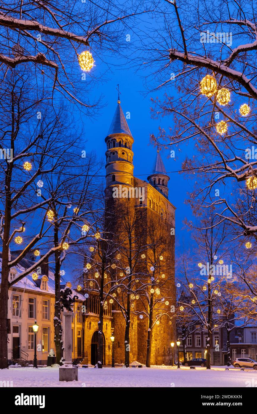 Basilica of Our Lady and the square during twilight, covered with fresh snow during winter time and illuminated with Christmas decoration, creating a Stock Photo