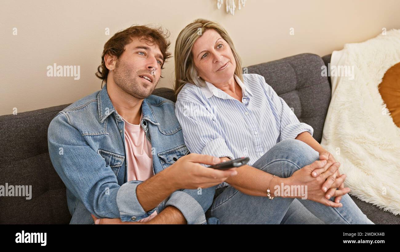 Mother and son restfully immersed in a movie at home, comfortably ...