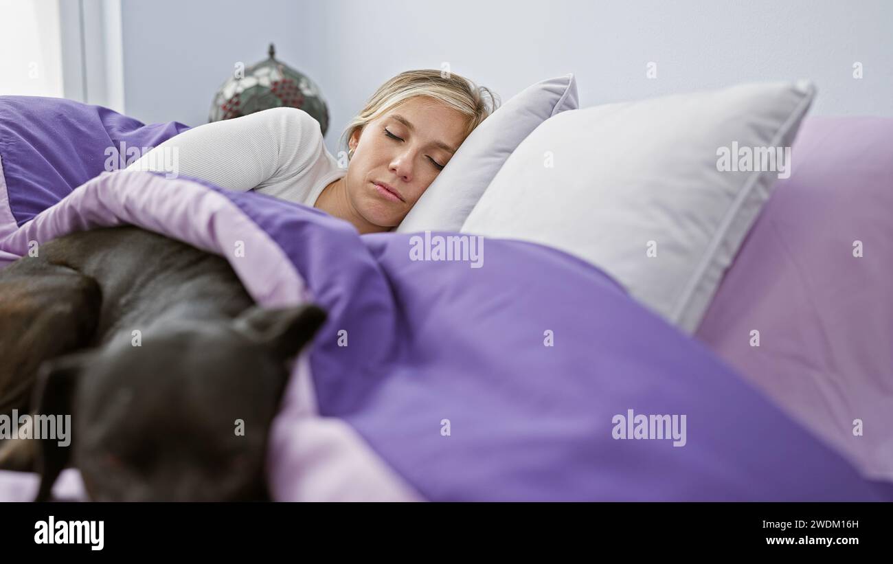 A young caucasian woman and her black labrador rest peacefully together ...