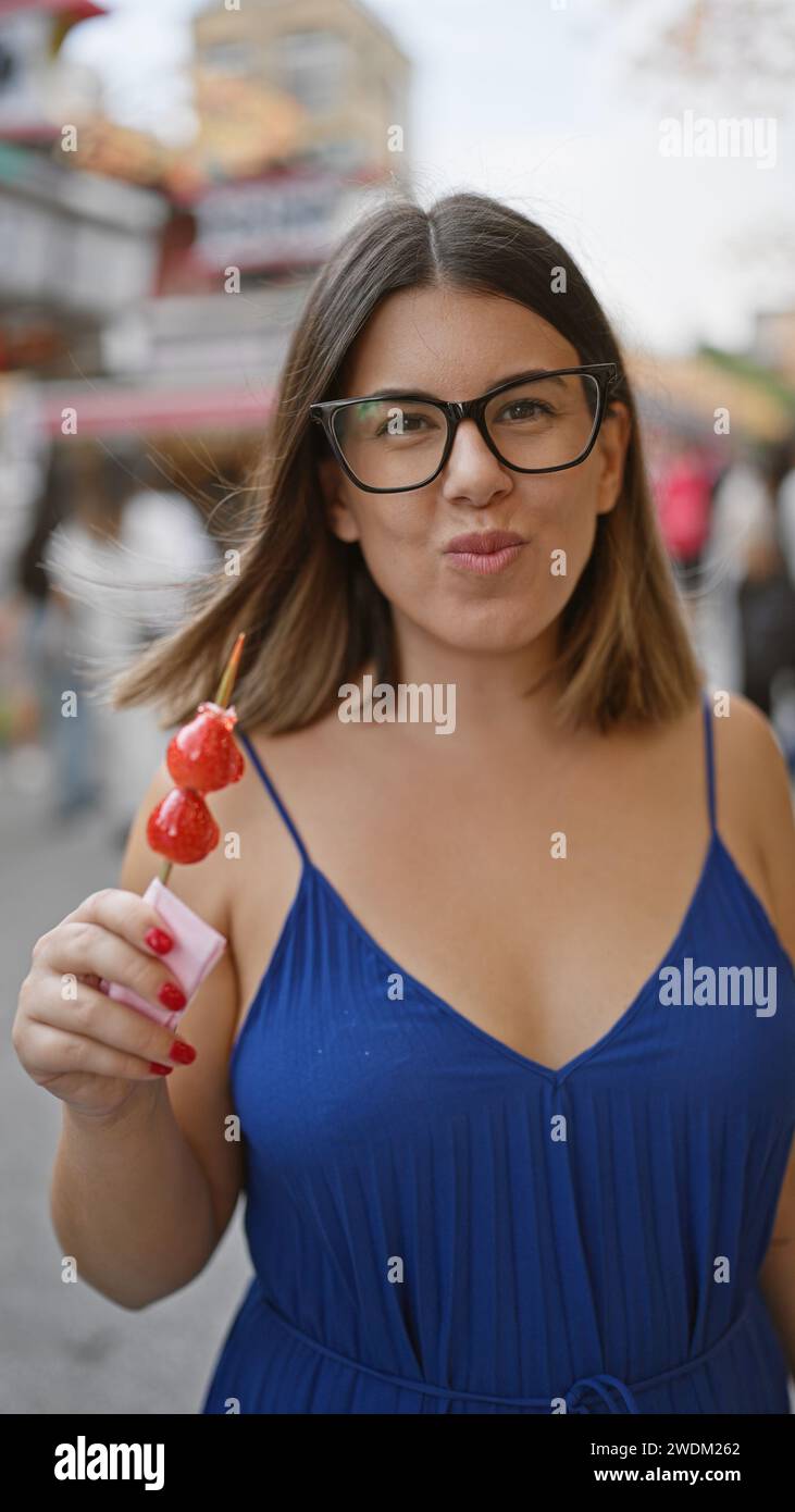 Stunning hispanic woman savors yummy japanese strawberry candy on