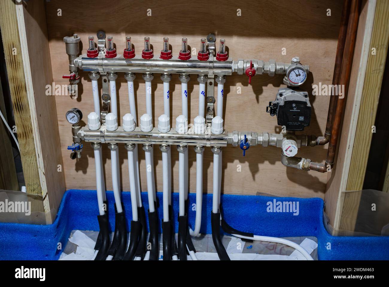 Underfloor heating manifold with flow and return pipes connected and