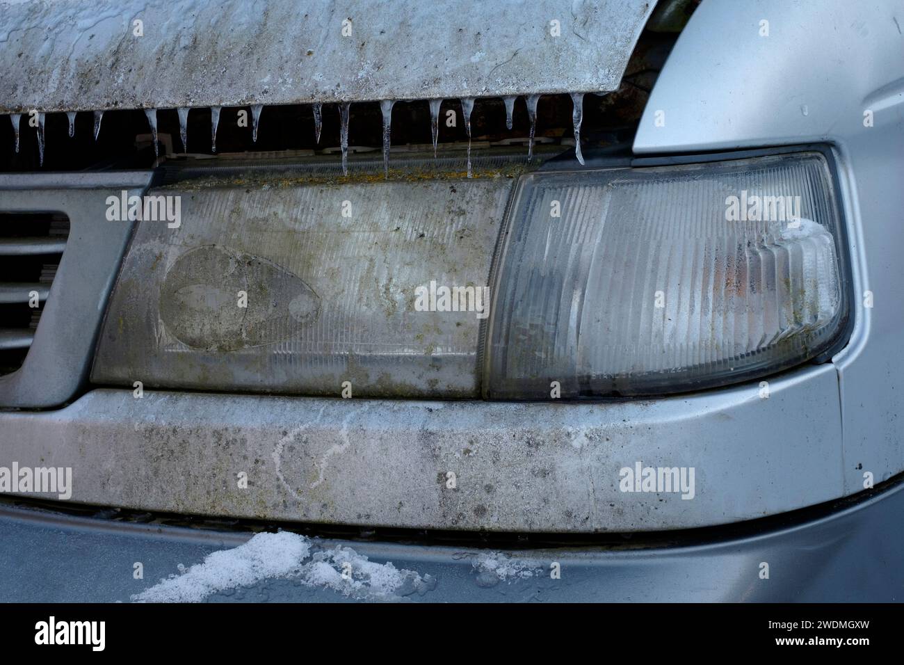 filthy dirty unwashed headlight on unkempt van illegal for road use Stock Photo
