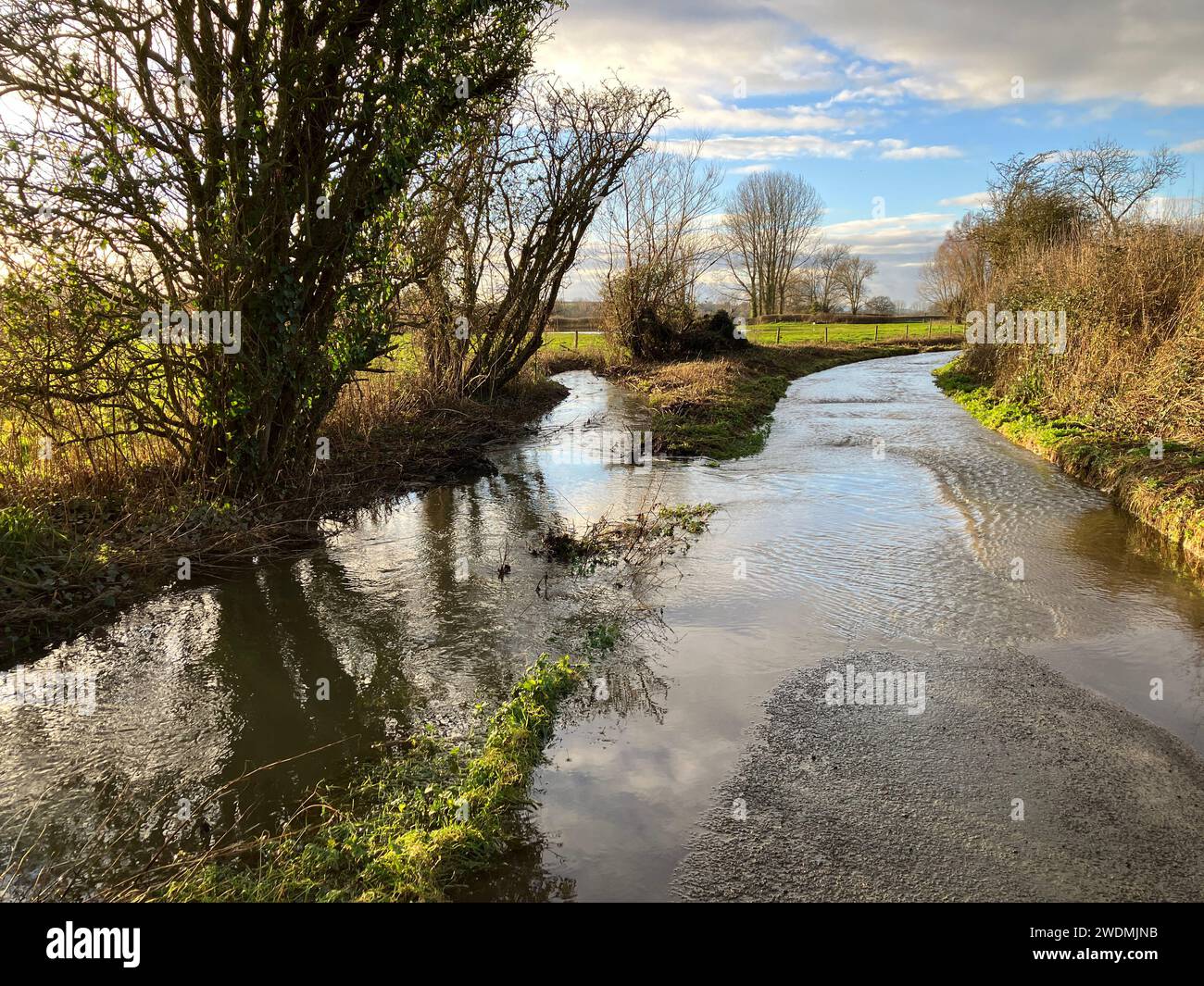 Stream which has burst its banks flooding a rural lane after Storm Henk, Somerset, England Stock Photo