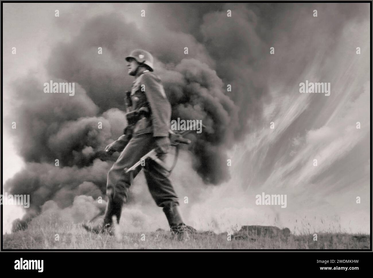 Operation Barbarossa with an advancing Nazi Wehrmacht soldier carrying a machine gun and wearing jack boots, with clouds of smoke in background from a burnt out Soviet village  It was the invasion of the Soviet Union by Nazi Germany and many of its Axis allies, starting on Sunday, 22 June 1941, during the Second World War. It was the largest land offensive in human history, with around 10 million combatants taking part Stock Photo