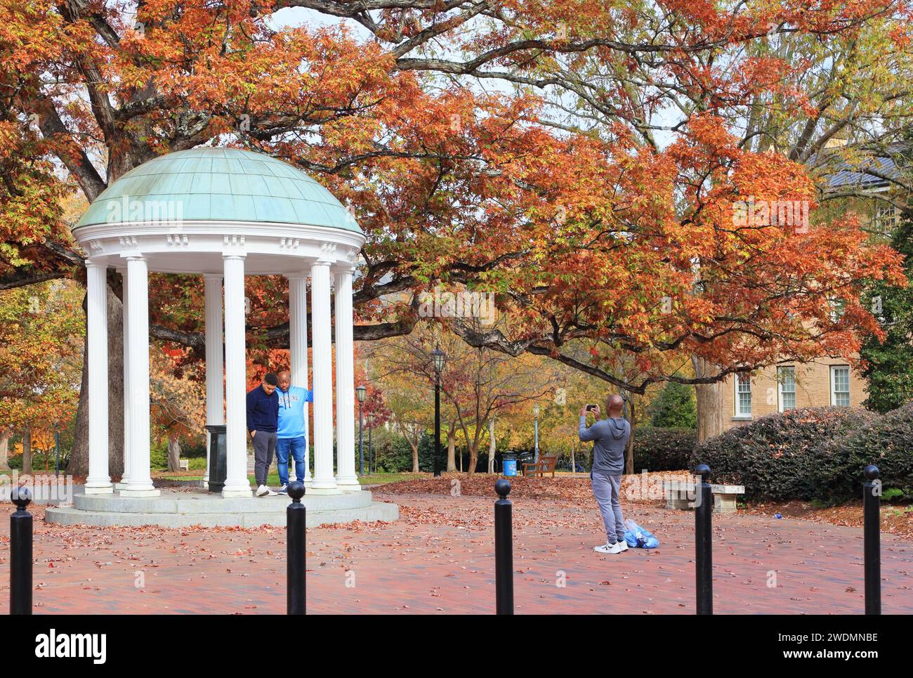 UNC University of North Carolina Chapel Hill NC. Old well with students taking photos.Fall, autumn. Stock Photo