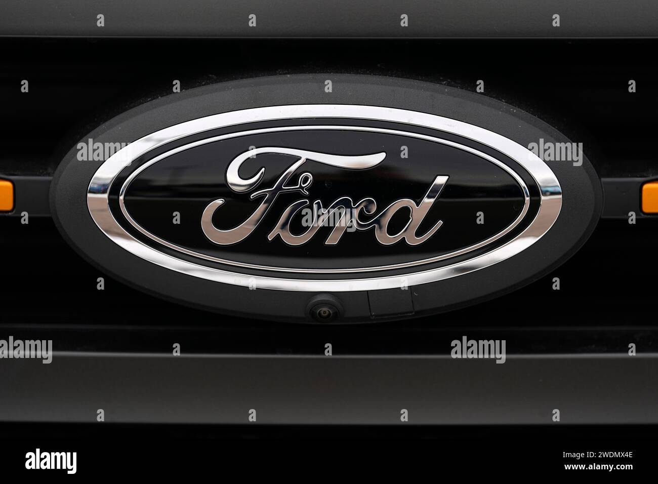 The company logo shines off the grille of an unsold 2024 F150 pickup