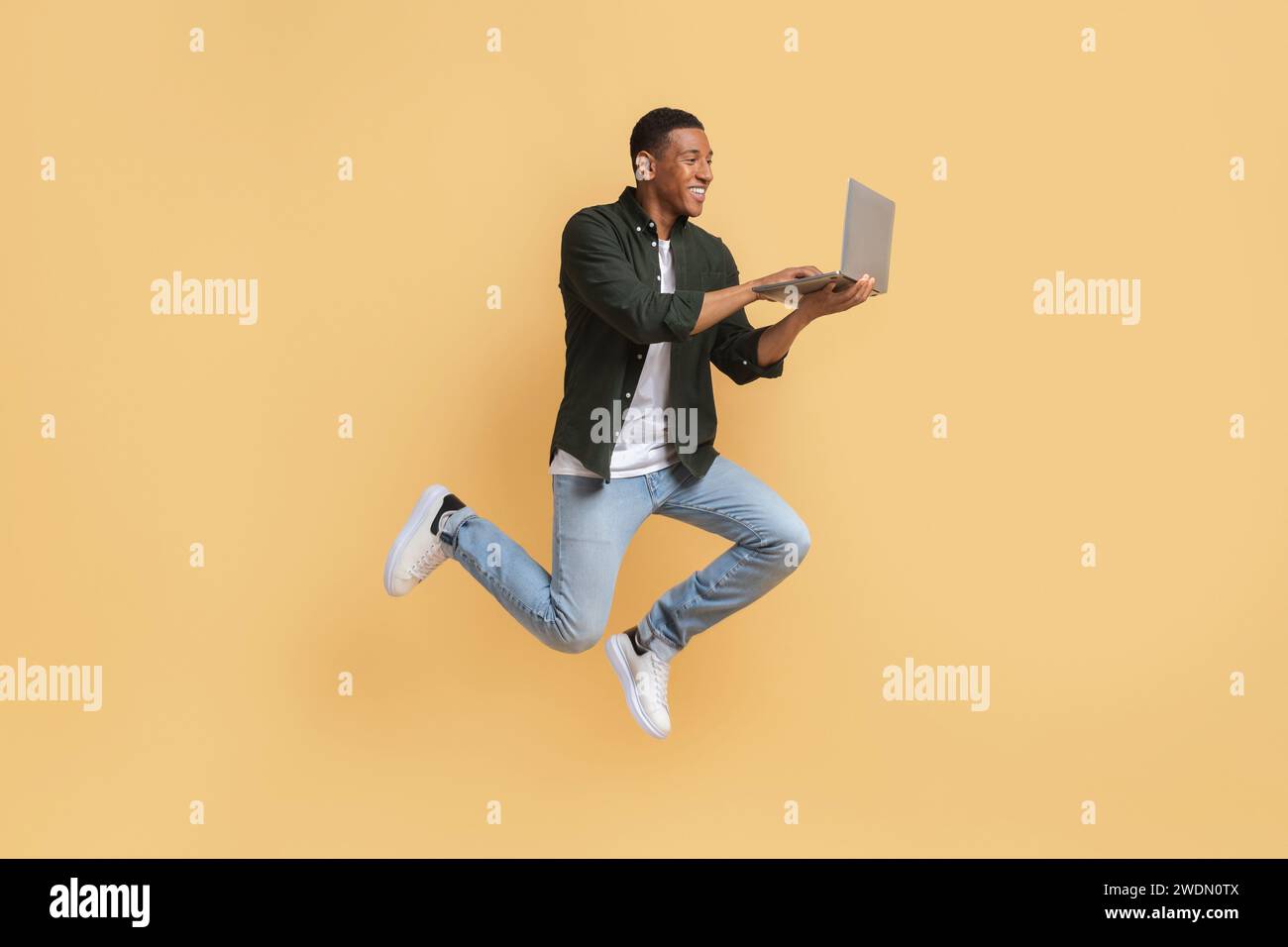 Excited young black guy independent contractor using computer Stock Photo
