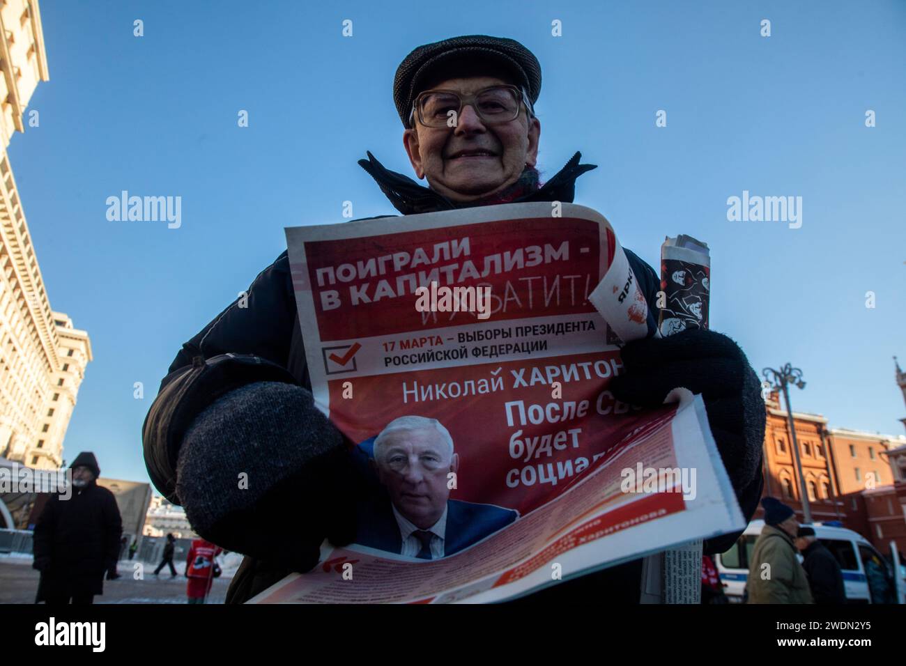 Moscow, Russia. 21st of January, 2024. Russian Communist supporter reads a campaign leaflet of the Nikolai Kharitonov presidential candidate of the Russian Federation as they walk to lay flowers at the Mausoleum of the Soviet founder Vladimir Lenin to mark the 100th anniversary of his death, in Red Square, Moscow, Russia. Credit: Nikolay Vinokurov/Alamy Live News Stock Photo