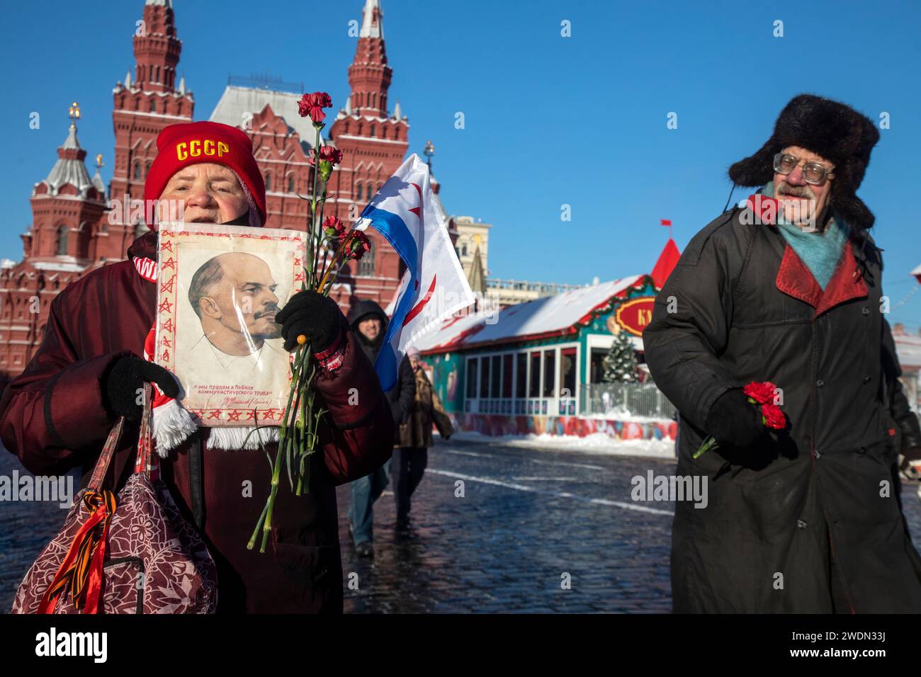 Moscow, Russia. 21st of January, 2024. Russian Communist supporters carry portrait of Vladimir Lenin as they walk to lay flowers at the Mausoleum of the Soviet founder Vladimir Lenin to mark the 100th anniversary of his death, in Red Square, Moscow, Russia. Credit: Nikolay Vinokurov/Alamy Live News Stock Photo