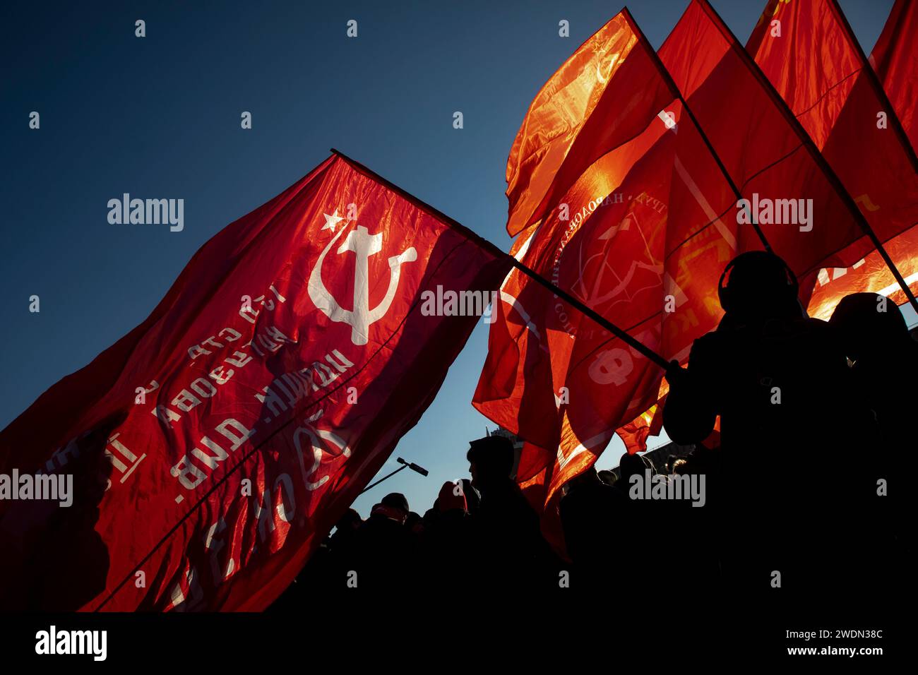 Moscow, Russia. 21st of January, 2024. Russian Communist supporters carry red flags as they walk to lay flowers at the Mausoleum of the Soviet founder Vladimir Lenin to mark the 100th anniversary of his death, in Red Square, Moscow, Russia. Credit: Nikolay Vinokurov/Alamy Live News Stock Photo