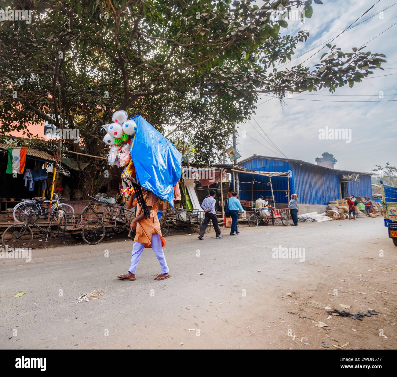 Local lifestyle: a local man walking in the street (Strand Bank Road) selling toys in Kolkata (Calcutta), West Bengal, India Stock Photo