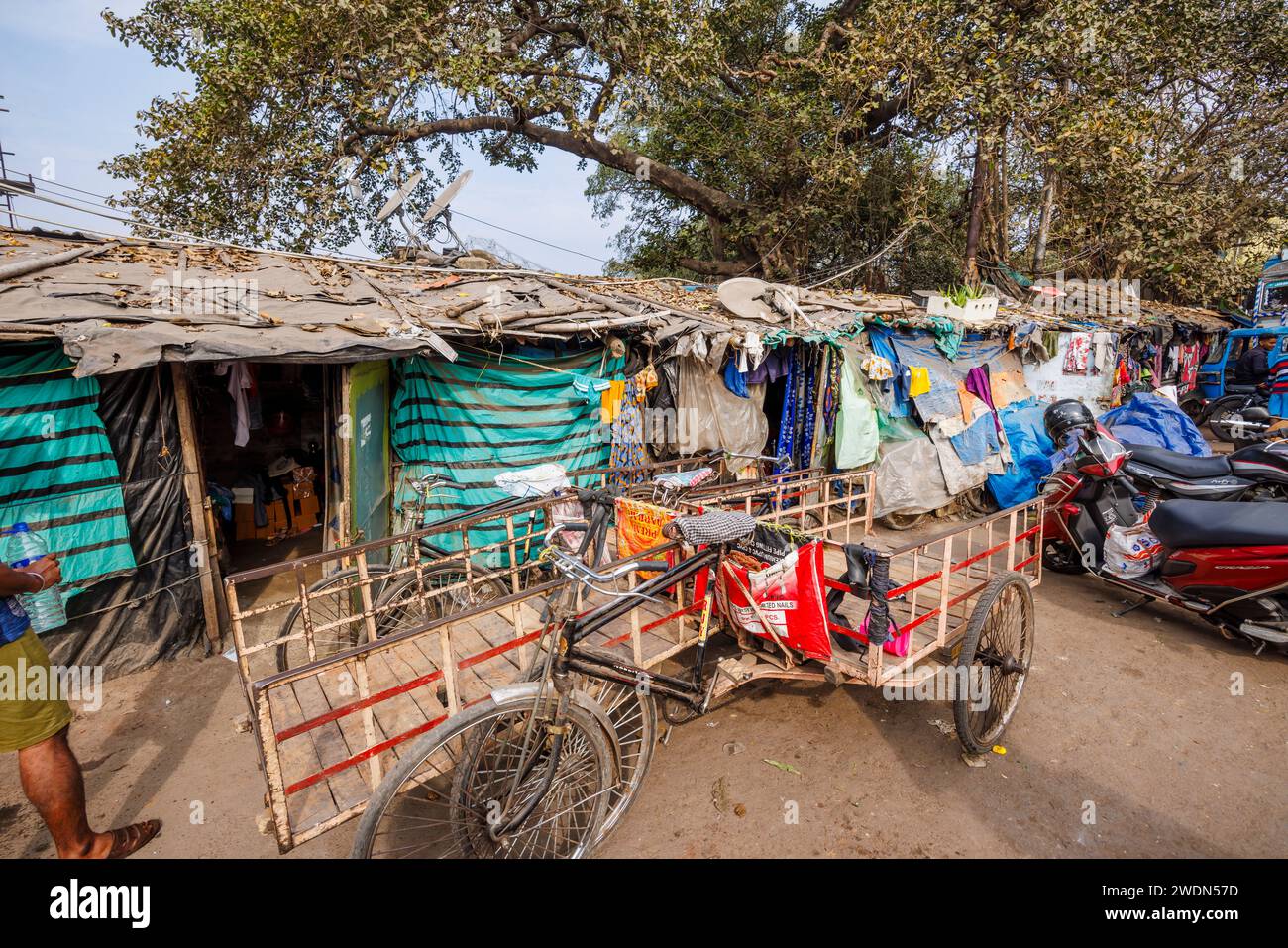 A tricycle parked outside slum condition housing in Strand Bank Road, Kolkata (Calcutta), West Bengal, India Stock Photo