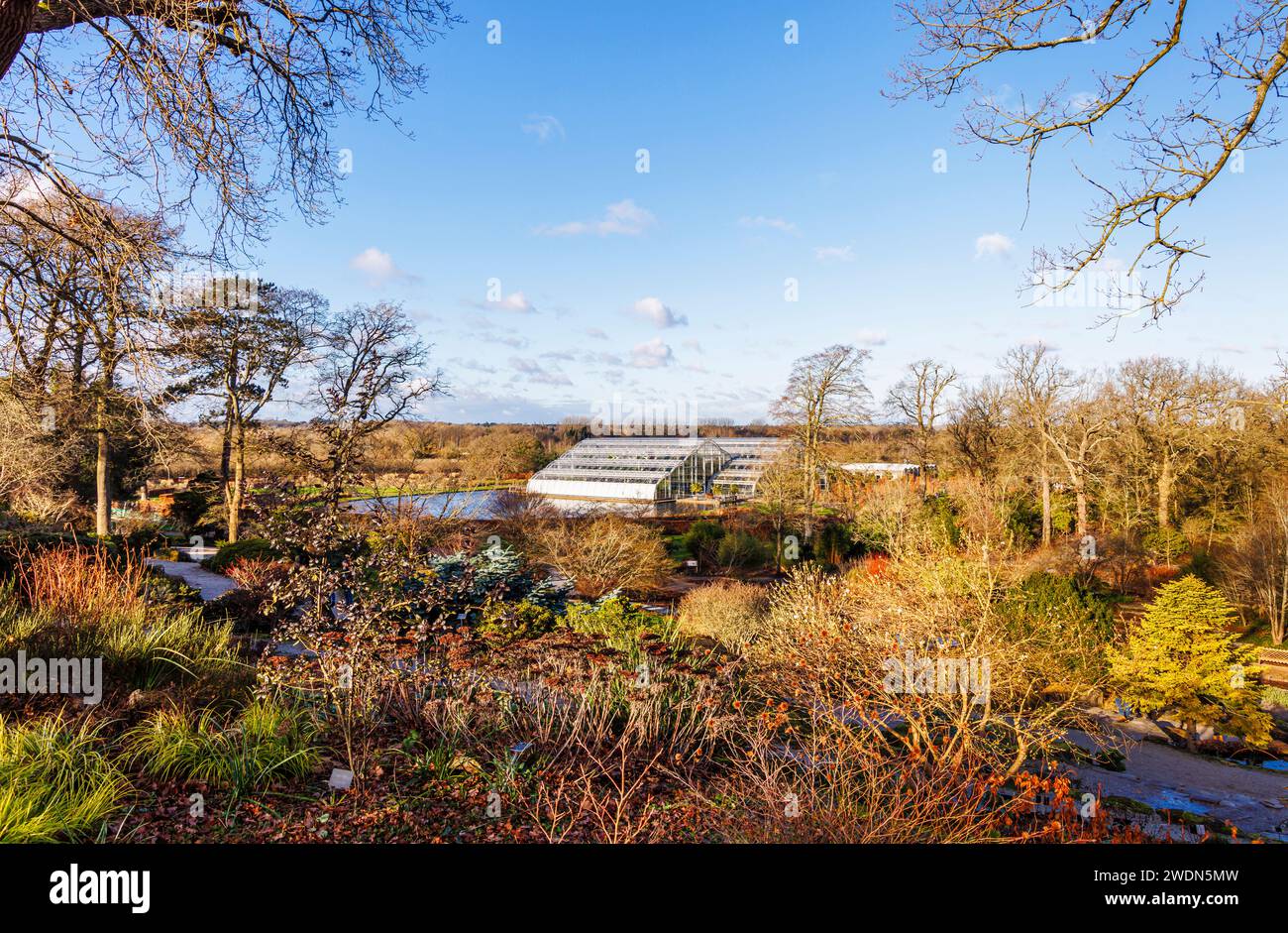 The iconic Glasshouse and lake seen from the Rock Garden at RHS Garden ...