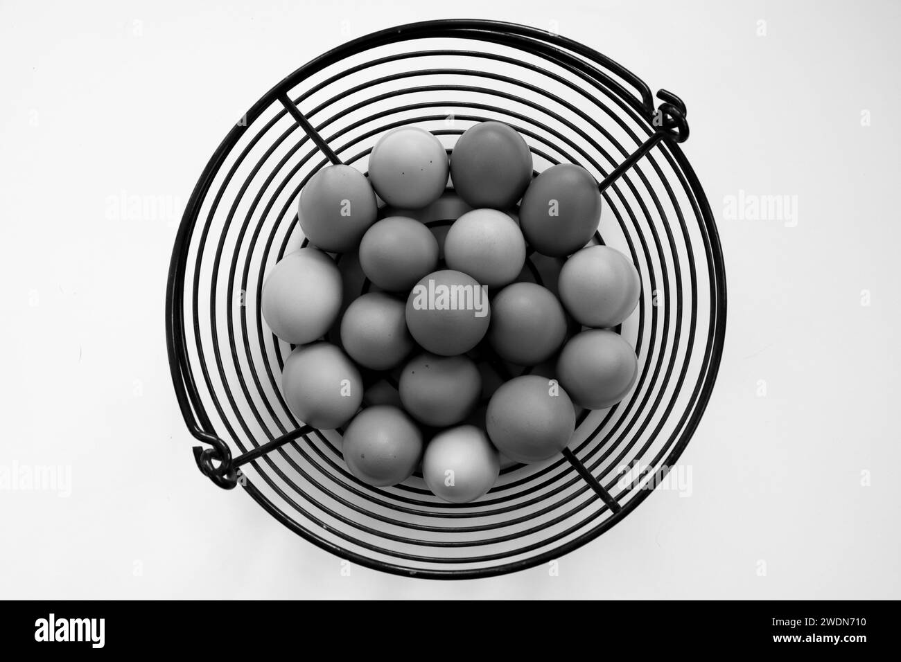 Black and white photograph of free range chicken eggs on white