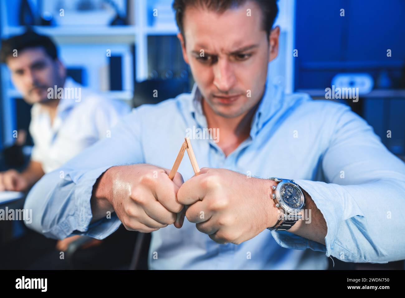 Stressful burnout of businessman destroying pencil for venting emotion in overwork load at night time, supported by business partner to solve issue Stock Photo
