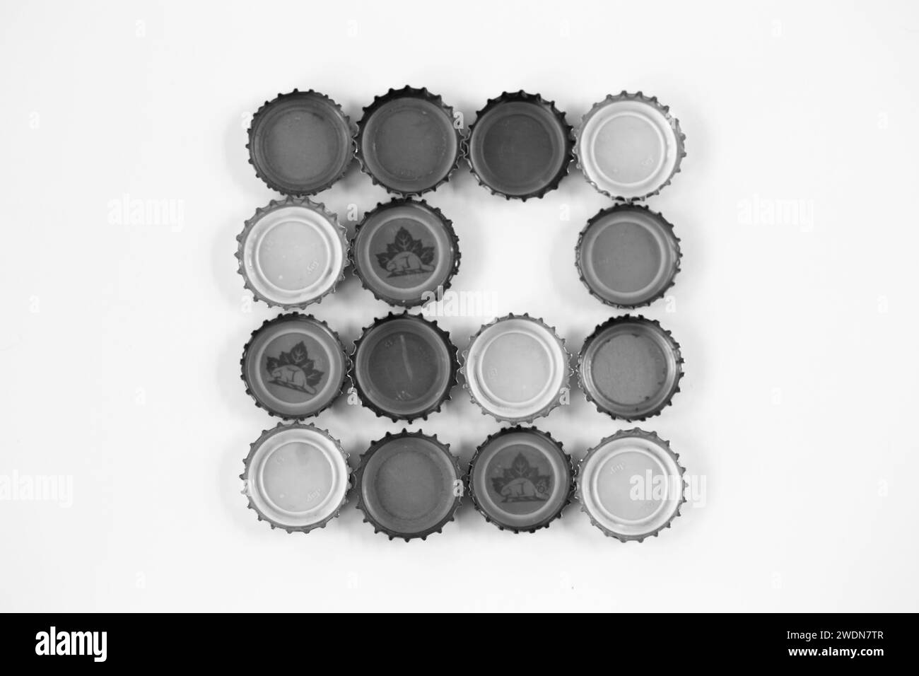 A grouping of upside down bottle caps on a white background Stock Photo