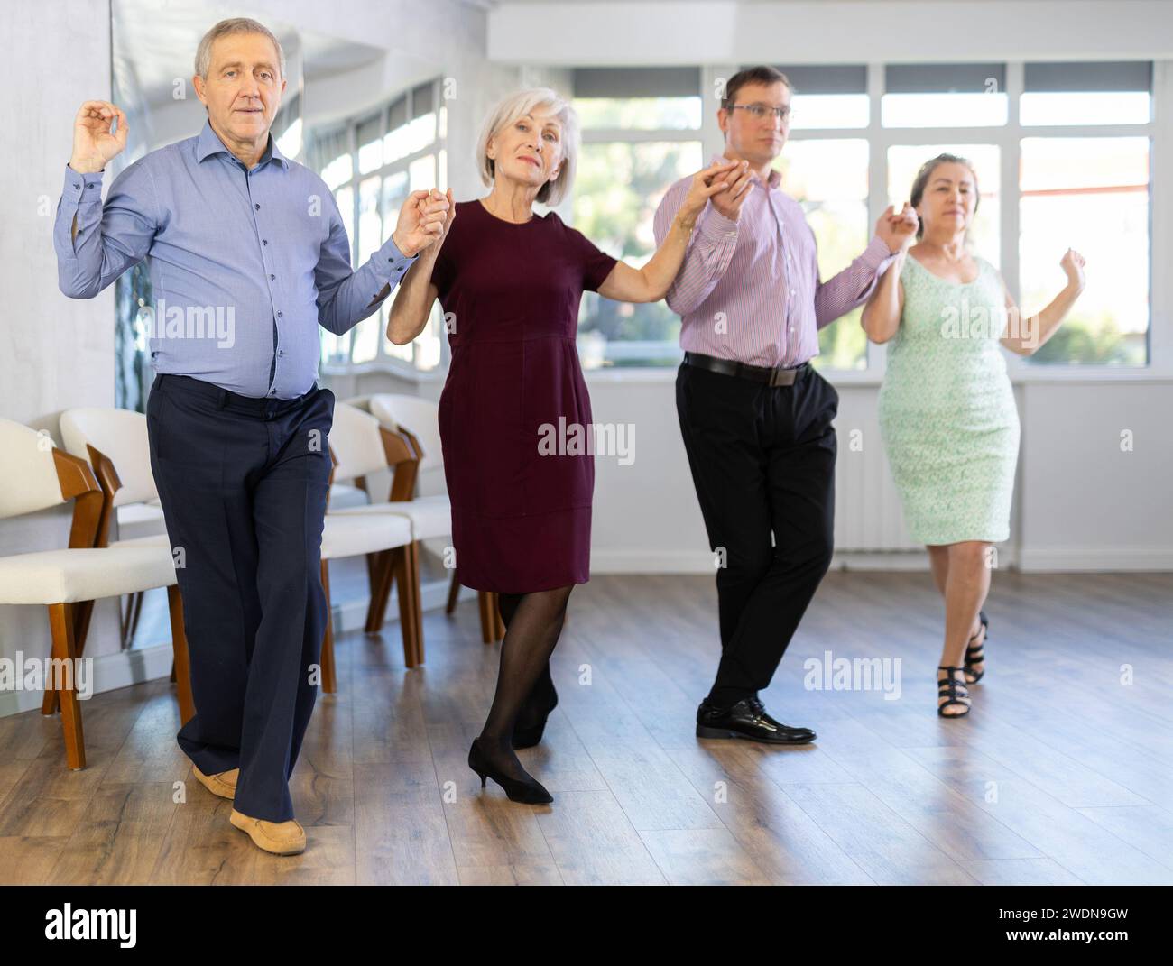 Group of elderly people with middle-aged man perform Irish folk dance Stock Photo