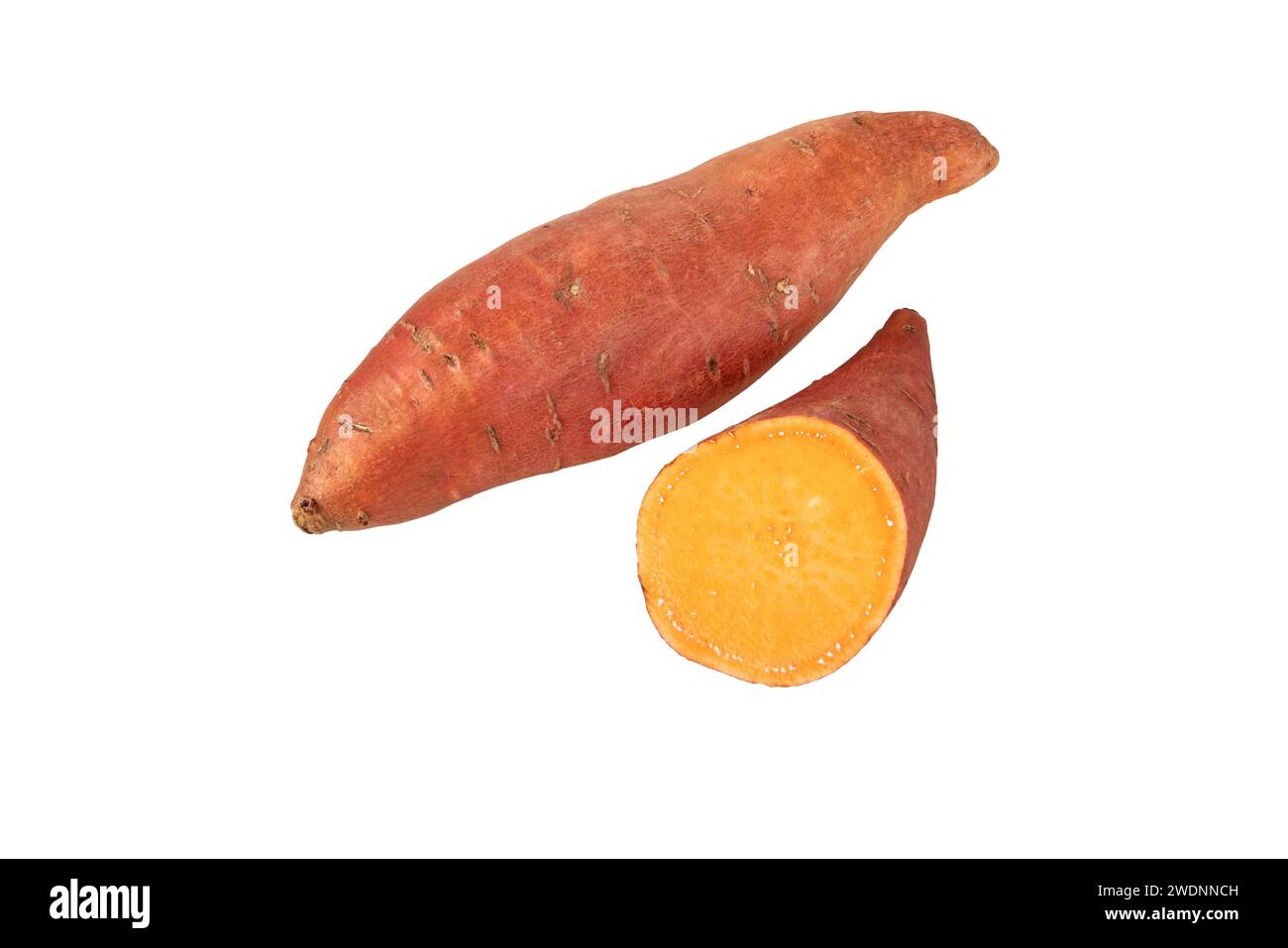 Sweet potato or sweetpotato whole and half tubes with red skin and yellow flesh isolated on white. Vegetable food staple. Stock Photo