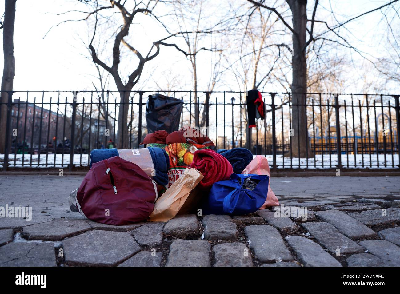 A migrants possessions who has been forced out of shelters lie on the sidewalk as he awaits to be redirected to other shelters in Tompkins Square on the East Side of Manhattan on January, 21, 2024 in New York City. New York City imposed a new directive effectively displacing single adult migrants from shelters forcing them to reapply for new lodging after an initial period of 30 days. Several volunteer groups have been providing hot meals and warm clothing in the interim during the increasingly cold temperatures. (Photo by John Lamparski/SIPA USA). Stock Photo