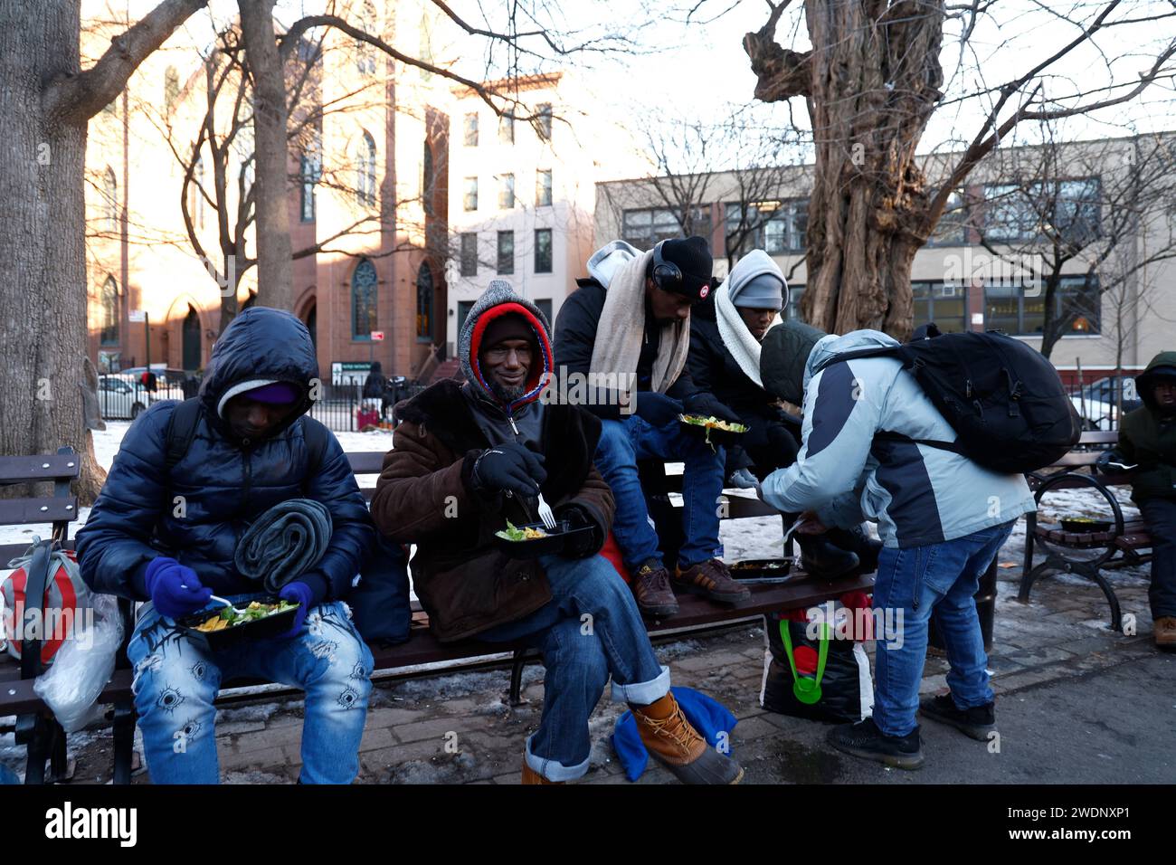 Migrants who have been forced out of shelters receive food and clothing donations as they await to be redirected to other shelters in Tompkins Square on the East Side of Manhattan on January, 21, 2024 in New York City. New York City imposed a new directive effectively displacing single adult migrants from shelters forcing them to reapply for new lodging after an initial period of 30 days. Several volunteer groups have been providing hot meals and warm clothing in the interim during the increasingly cold temperatures. (Photo by John Lamparski/SIPA USA). Stock Photo