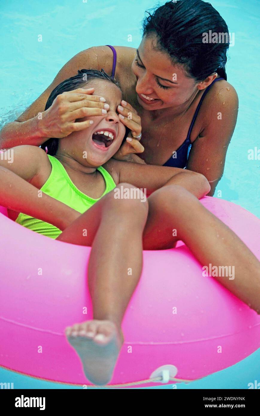 Mother and daughter  laughing while playing on an innertube while on vacation at the seashore Stock Photo