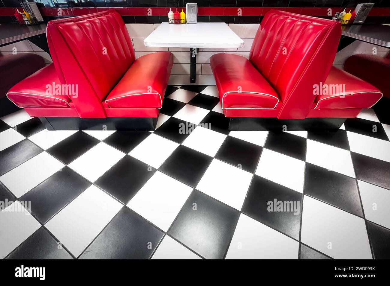 The checkered tile floor and red seats of a retro fifties style diner near El Paso, Texas. Stock Photo