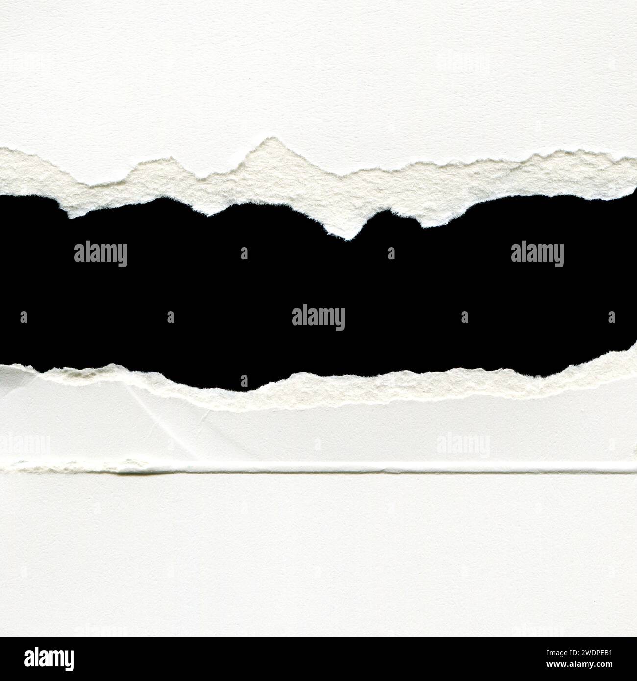 Hole ripped in white paper with black space for your message. Stock Photo