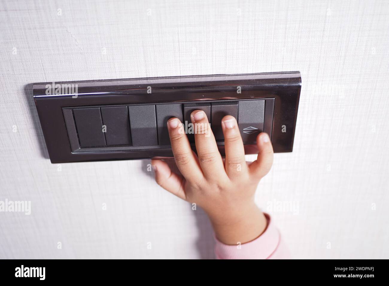 child finger turning on lighting switch with copyspace  Stock Photo
