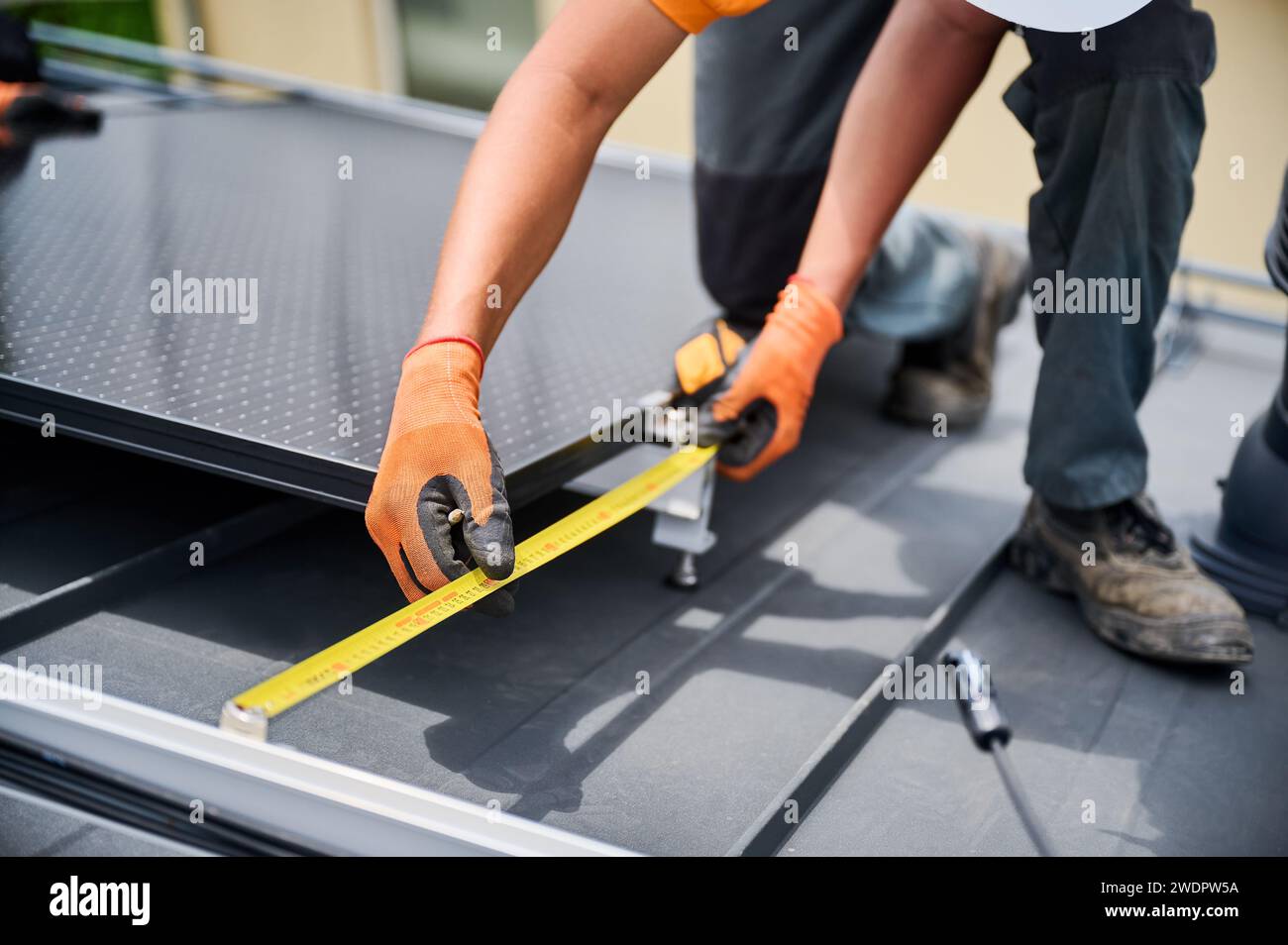 Worker building solar panel system on rooftop of house for generating ...