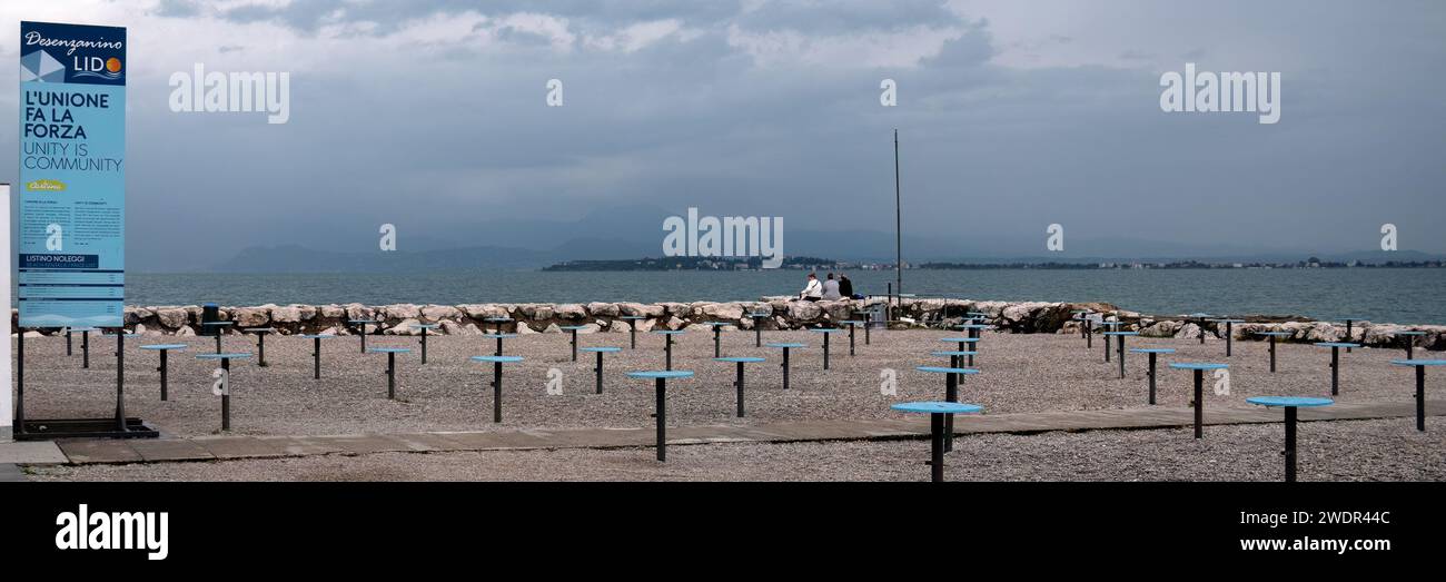 DESENZANO DEL GARDA, ITALY - SEPTEMBER 22, 2023:   Panorama view of a community area on the beach with sign Stock Photo
