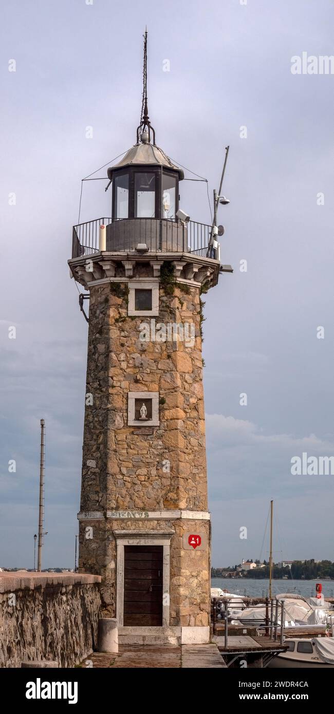 DESENZANO DEL GARDA, ITALY - SEPTEMBER 22, 2023:  Upright panorama view of Lighthouse (Faro di Desenzano del Garda) and boats in the harbour Stock Photo