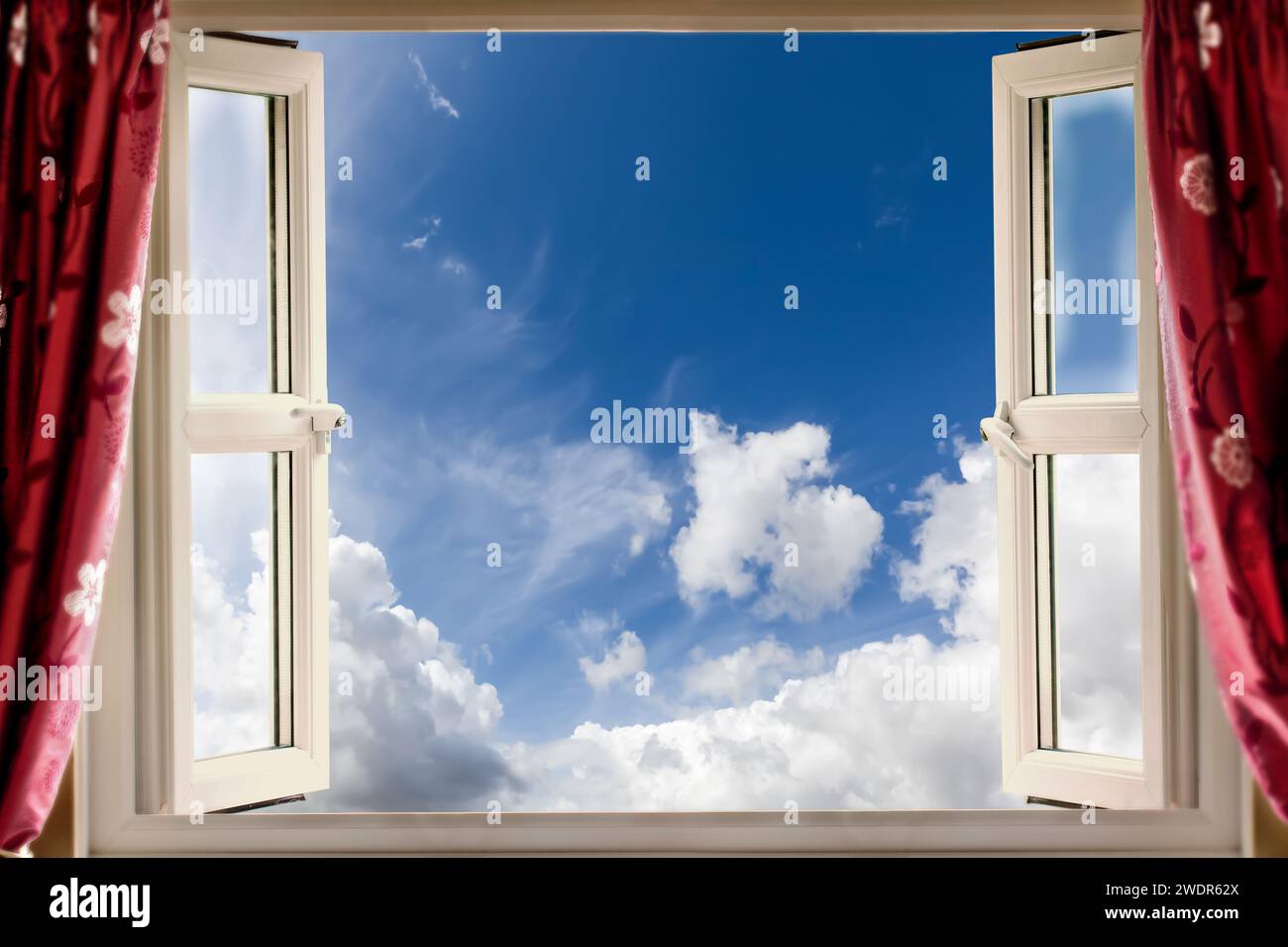 Open window looking out to blue skies and fluffy white clouds in the summer. Fresh clean air concept Stock Photo