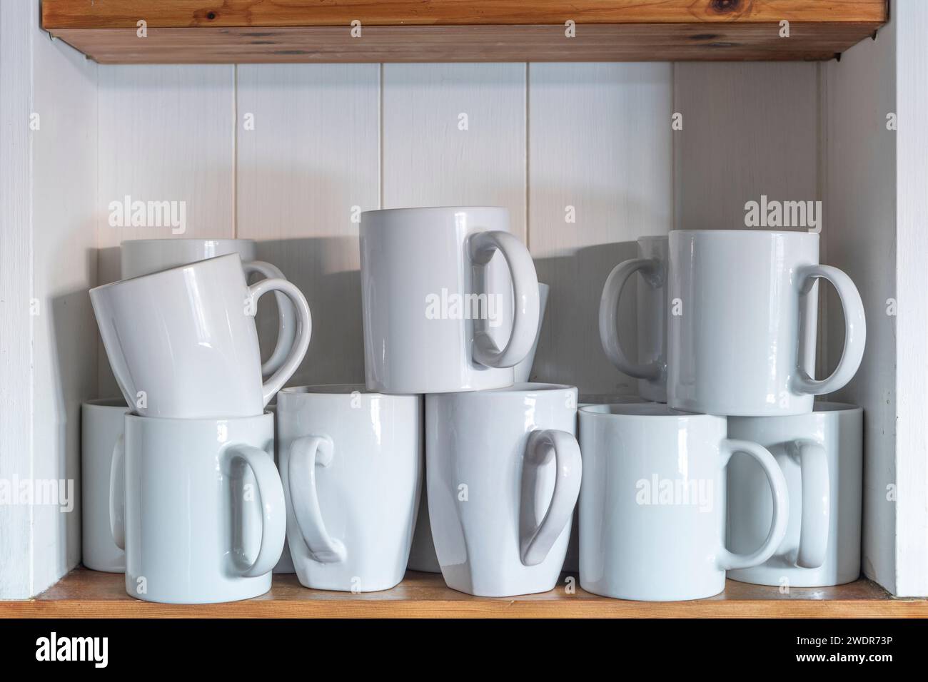 White coffee mugs on a shelving unit Stock Photo Alamy