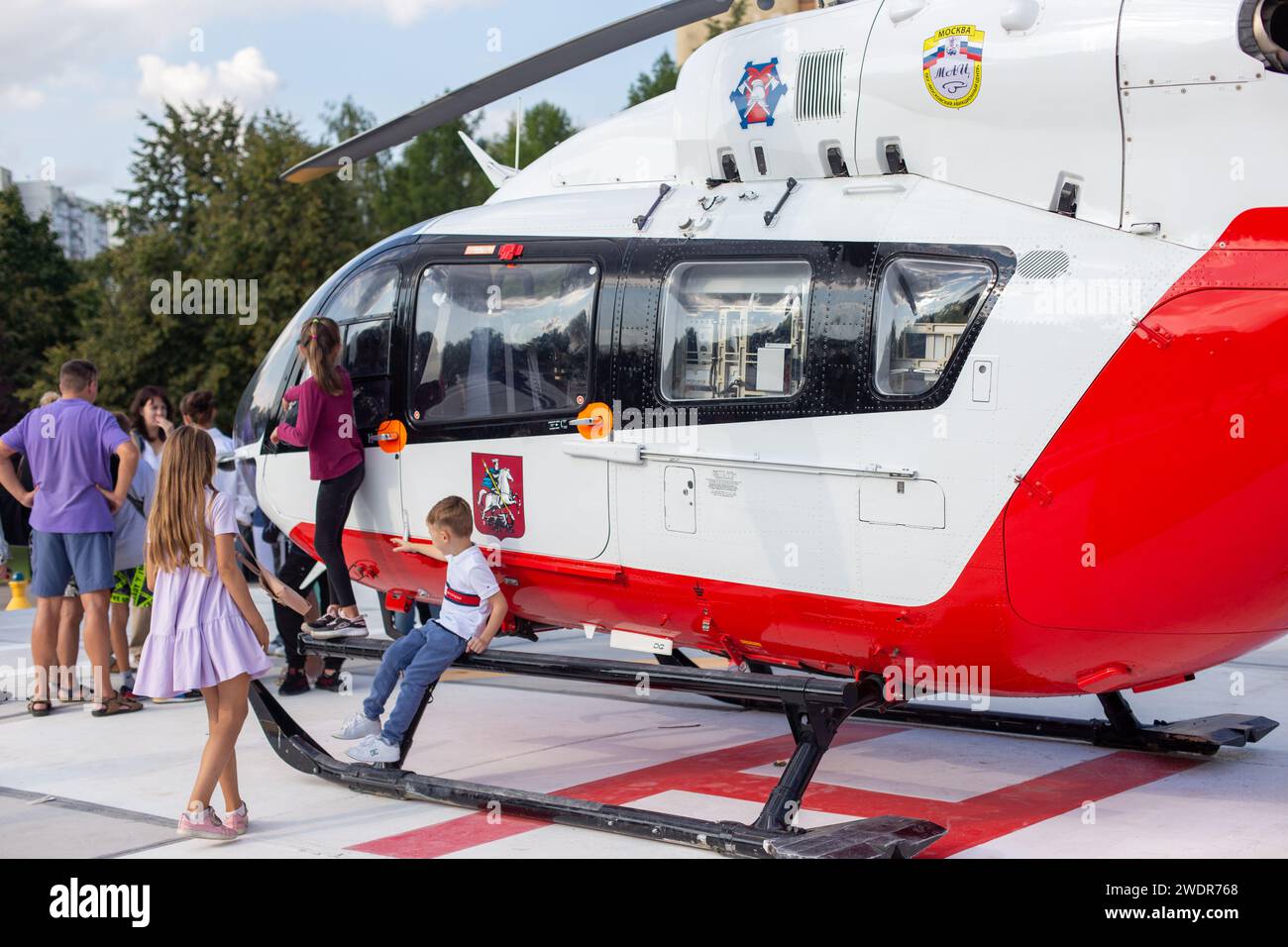 Moscow, Moscow region, Russia - 03.09.2023:Children and adults walk near an ambulance rescue helicopter, on a sunny summer day Stock Photo