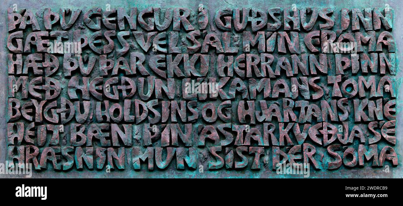 Closeup of entrance plaque on wall of Hallgrimskirkja church in Reykjavik with Icelandic words Come in to Gods house keep well in mind my pious soul d Stock Photo