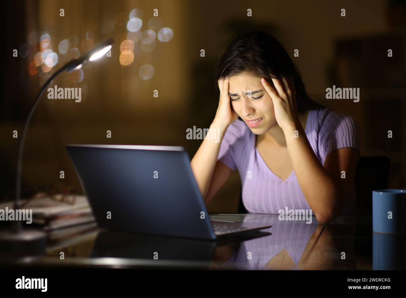 Concerned woman with laptop in the night at home Stock Photo