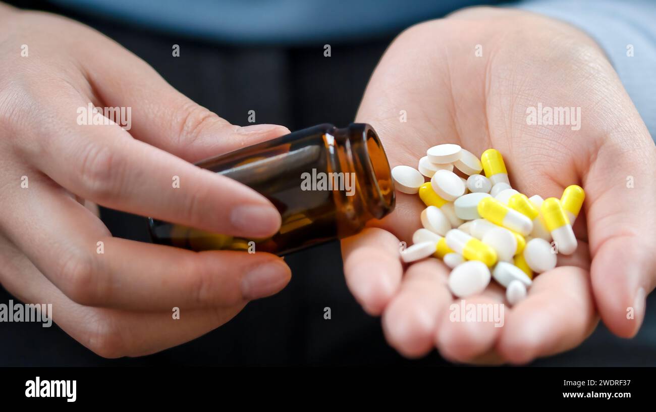 Pours out from bottle pills into palm, taking medication and nutritional supplements. Medicine for my headache. Healthcare Concept Stock Photo