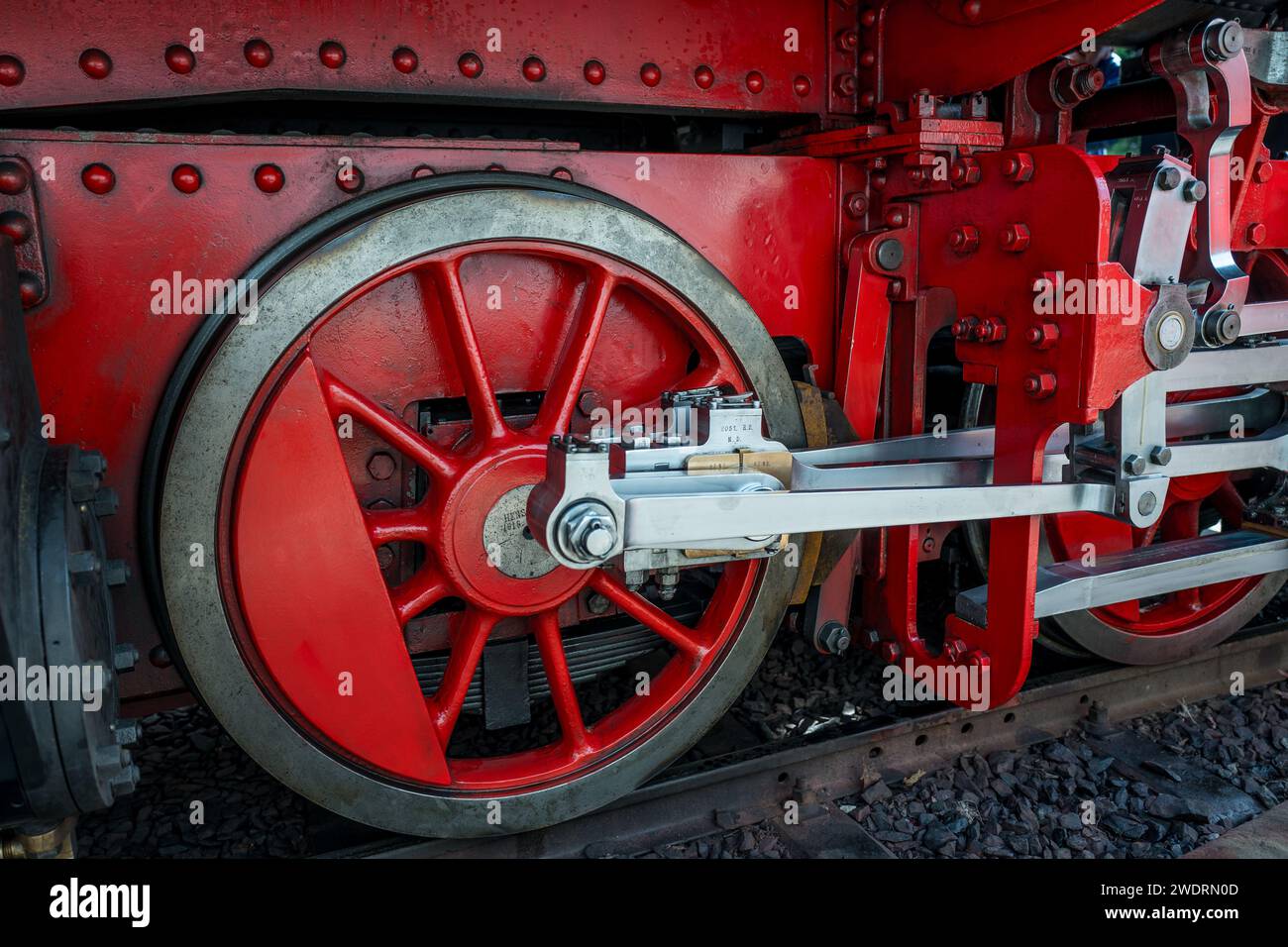 A closeup shot of a red train wheels on the tracks Stock Photo