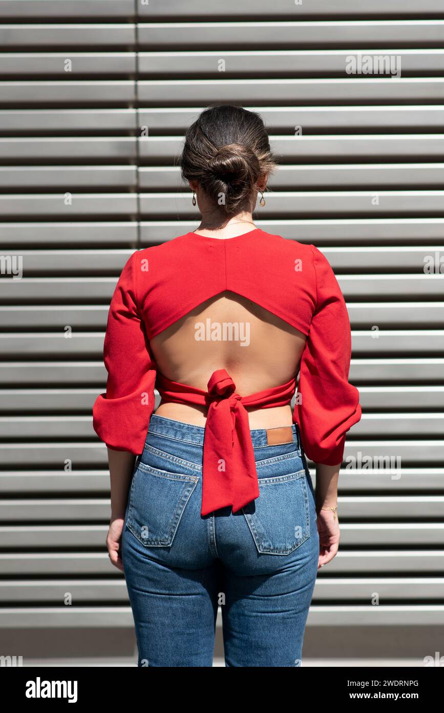Rear view of woman in red standing outdoors Stock Photo - Alamy