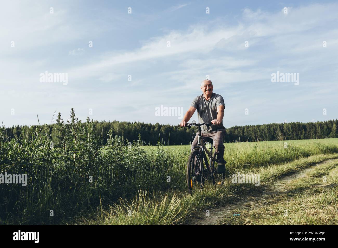 Senior man riding his bike outdoors Stock Photo
