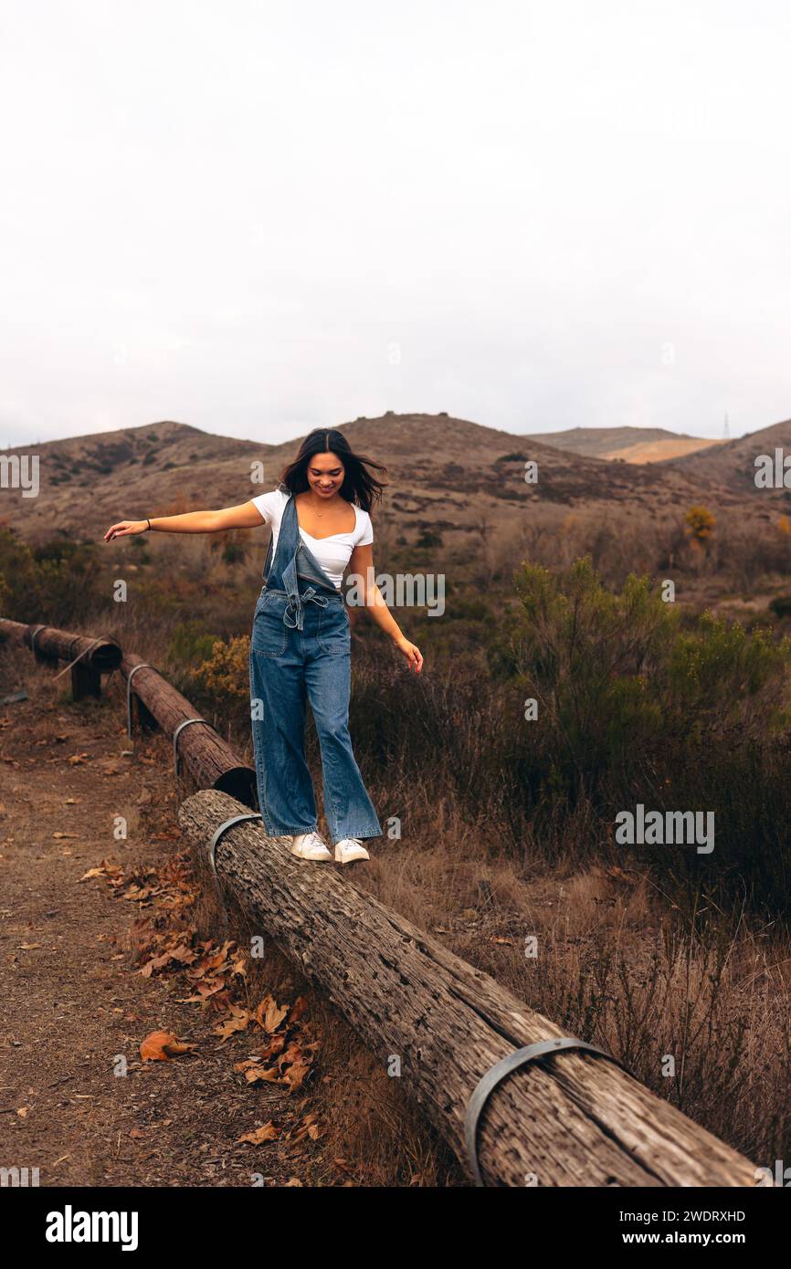 Women walking towards camera on log on hiking trail Stock Photo