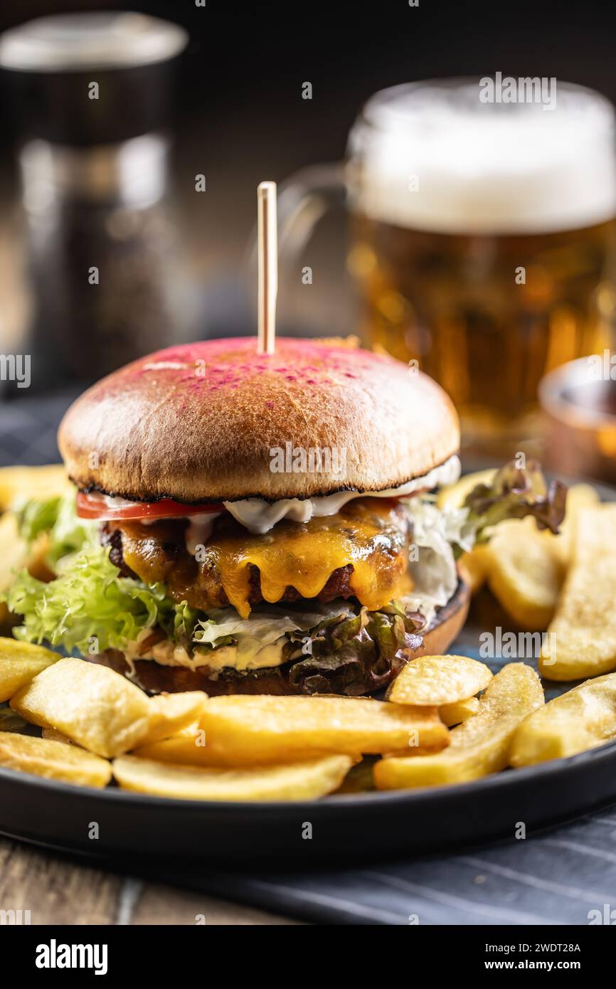 Beef burger with fries and draft beer on a pub or restaurant plate. Stock Photo