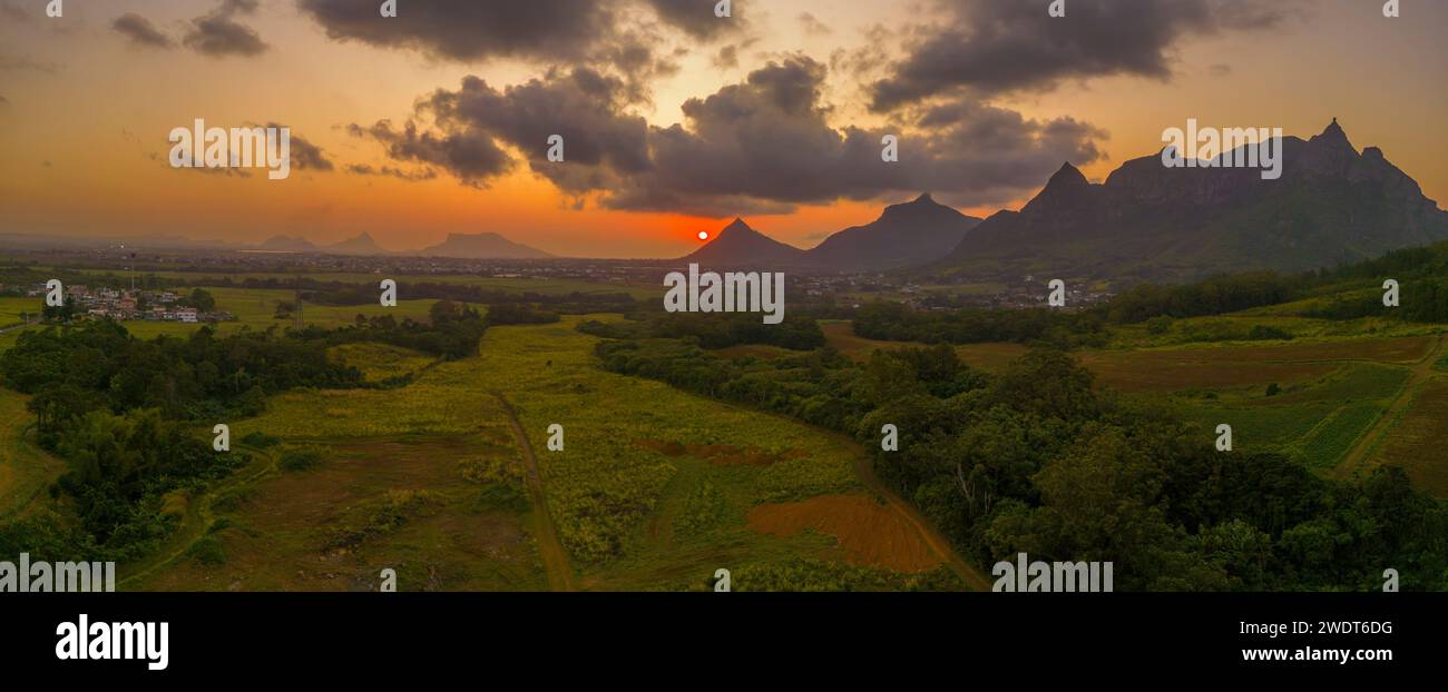 View of golden sunset behind Long Mountain and patchwork of green fields, Mauritius, Indian Ocean, Africa Stock Photo