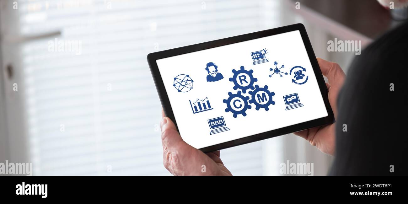 Crm concept shown on a tablet held by a man Stock Photo